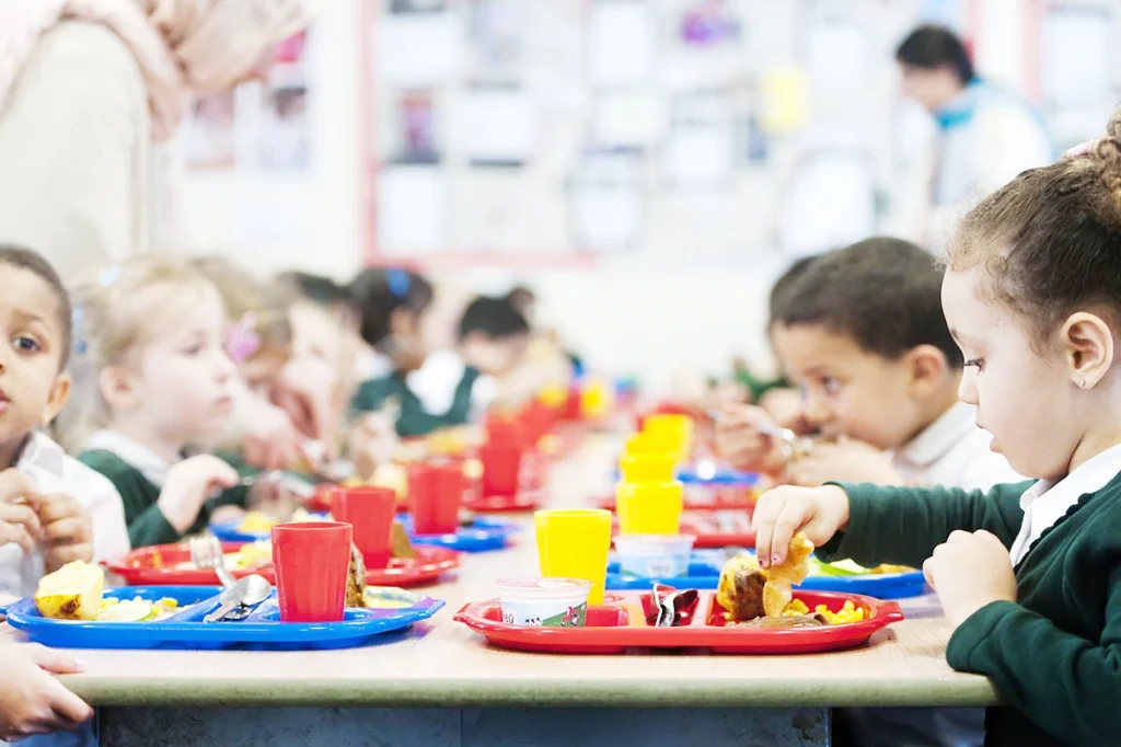 Primary school pupils eating school dinner