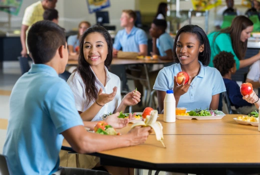Students talking in the cafeteria at lunchtime
