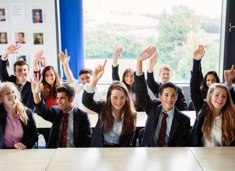 Students raising their hands in class
