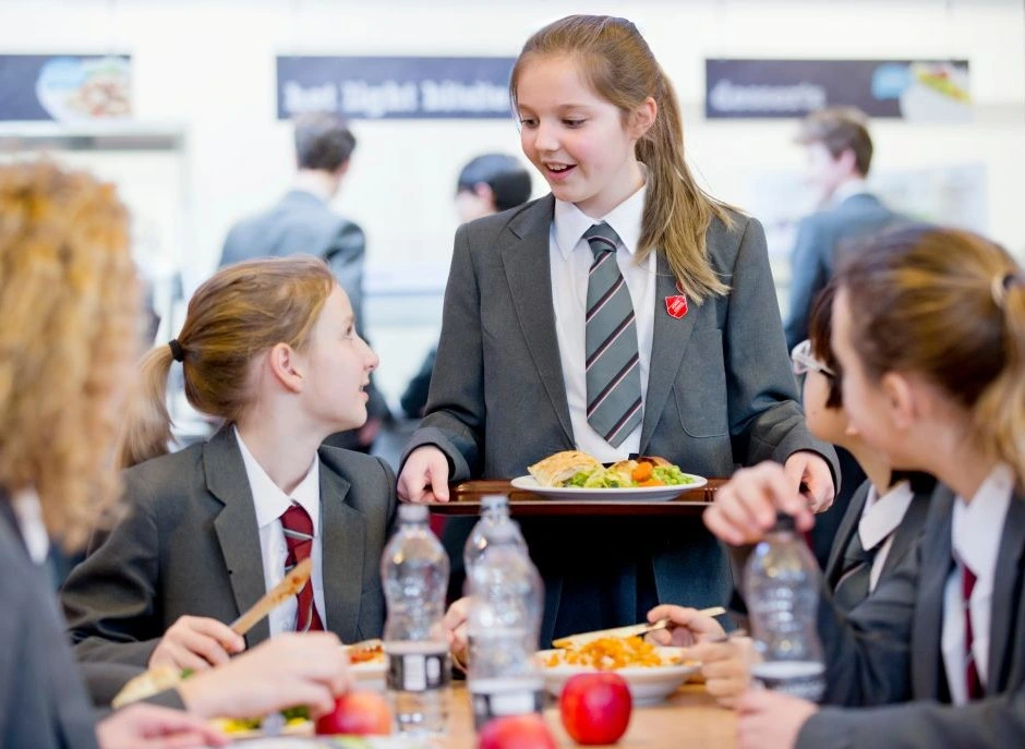 Students enjoy a free school meal at lunchtime